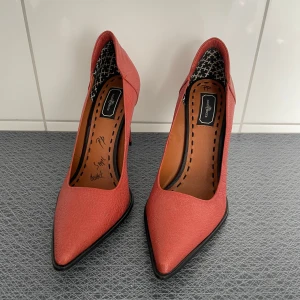Malene Birger pumps med spetsig tå - Säljer ett par stilrena rosa pumps från Malene Birger med spetsig tå och klack. Skorna har en elegant form och är tillverkade i skinn med slät yta. Perfekta för dig som vill addera färg till outfiten.