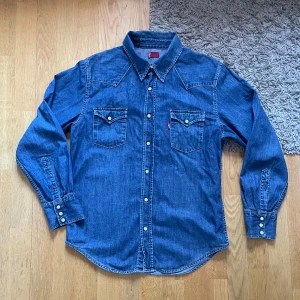 Levi's Jeansskjorta   - Levis Jeansskjorta Red Tab - skjortan är i utmärk skick, har endast använd ett fåtal gånger, men känns fortfarande som ny - Ord.pris 900. Tveka inte att skriva vid fler funderingar!🤩