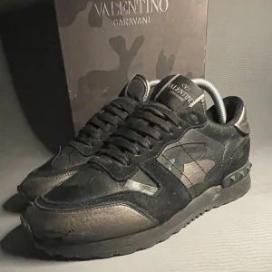 Svarta Valentino Rockrunners - Säljer ett par svarta Valentino Rockrunner med mocka och skinn. Skorna har svarta nitar på hälen och är as feta. Snygg  design och kommer med box och kvitto, st 36,5 men passar 37