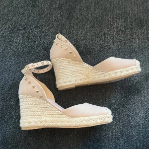 Beige Espadrillos wedges med nitar - Säljer ett par snygga beigea Espadrillos med kilklack och öppen tå och ankelrem med guldfärgade nitar💗 så fina! Endast använda ett kort tillfälle inomhus på ett event