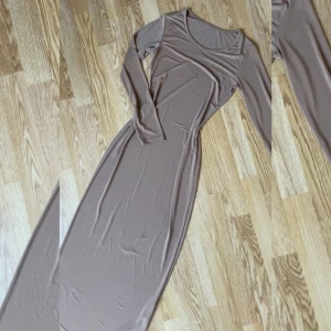 Beige maxiklänning med lång ärm - Säljer en stilren beige långklänning med rund halsringning och långa ärmar. Klänningen har en figurnära passform och är tillverkad i ett mjukt, stretchigt material som sitter snyggt på kroppen. Perfekt för dig som gillar minimalistisk stil. Aldrig använd 