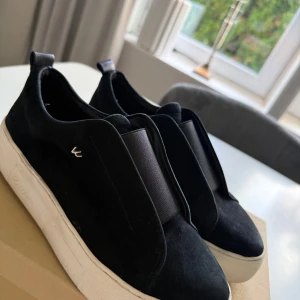 Svarta sneakers från K.COBLER - Säljer ett par svarta sneakers från k cobler med vit platt sula, skorna är använda ett fåtalsgånger. Nästan som helt nya. Tveka inte på att höra av er om ni har några frågor eller funderingar! 😊