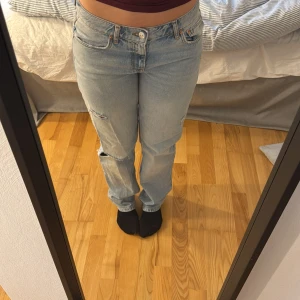 Ljusblå lågmidjade jeans med hål - Ljusblå jeansbyxor med låg midja, raka ben och slitningar. Storlek 38 men skulle säga att dem sitter mer som en 36. 
