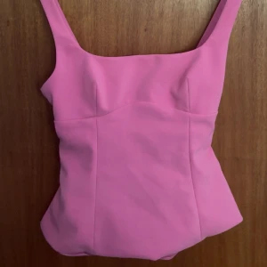 Rosa topp med rosett - Supersöt oanvänd rosa topp från Zara. Toppen har en snygg rosettdetalj och lite öppen rygg🩷