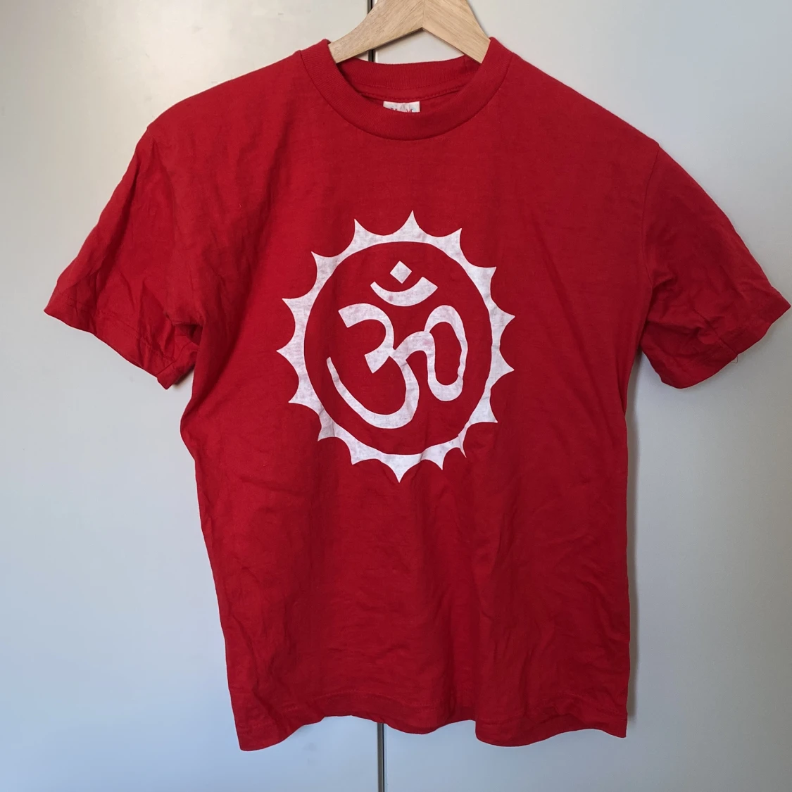 Orange-Röd t-shirt med vit Om-symbol