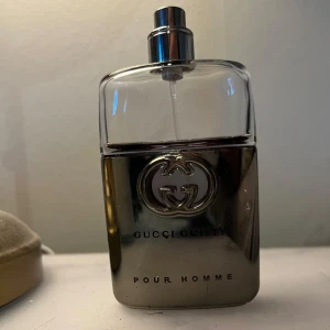 Gucci Guilty Pour Homme parfym - Gucci Guilty Pour Homme parfym i en stilren flaska med metallisk silverfärgad botten och genomskinlig ovandel. Flaskan har Guccis ikoniska logga i metall på framsidan och sprayfunktion upptill. Perfekt för dig som gillar lyxiga och maskulina dofter. 60% kvar finns inge lock 