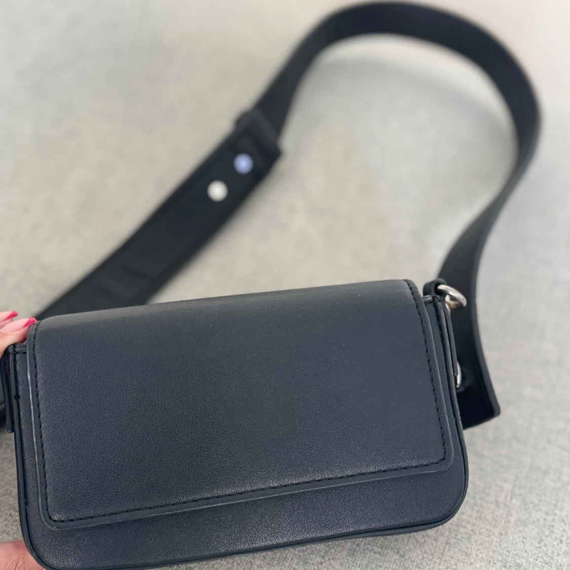 Svart axelväska i skinn med bred rem