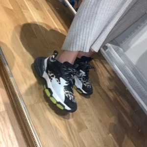 Chunky sneakers med leopardmönster - Snygga chunky sneakers i svart och vitt med coola leoparddetaljer och limegröna inslag på sulan. 