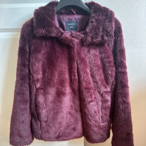 Vinröd fluffig höst vinter pälsjacka Lindex - Fluffig och supermjuk vinröd pälsjacka från Lindex med två fickor framtill.