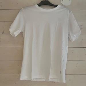 Vit t-shirt från Jack & Jones XS - Klassisk vit t-shirt från Jack & Jones Essentials i ekologisk bomull. Enkel och stilren design med rund hals och korta ärmar. Perfekt basplagg för dig som gillar en clean och fräsch look.