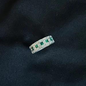 Silverring med gröna och vita stenar - Stilren silverring med rektangulär form, dekorerad med gröna och vita stenar i ett rutigt mönster. Ringen har en bred design och ger ett lyxigt intryck med sina glittrande detaljer. Perfekt för dig som vill sticka ut med något unikt.