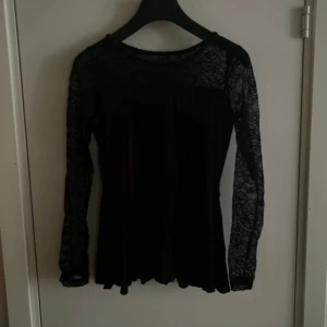 Svart spetsblus från cubus- storlek 146/152 - Elegant svart topp från Cubus i stolek 146/152. Den har långa spetsärmar och ett lätt utsvängt fall nedtill. Ärmarna är genomskinliga med ett vackert spetsmönster, medan kroppen är fodrad för teckning. Perfekt för både vardag och fest😊