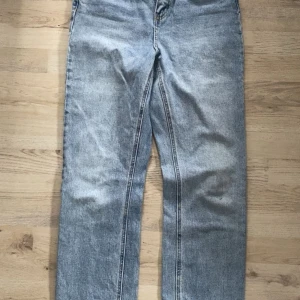 Ljusblå raka jeans i storlek 28/32 - Säljer ett par ljusblå jeans med rak passform och klassisk tvätt. Jeansen har normal midja och är tillverkade i ett mjukt bomullsmaterial. Perfekta för dig som gillar en avslappnad och tidlös look.