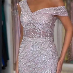 Glittrig ljusrosa långklänning - Magisk långklänning i ljusrosa med glittriga paljetter över hela klänningen från Dressroom i Göteborg i st.34. En typ av offshoulder-modell och slits framtill. Sitter figurnära och har ett elegant fall. Perfekt för bal eller fest. Endas använd den vid ett tillfälle. Klänningen passar även en lite större 32. Prislapp och kvitto finns även som bevis. Priset går att diskutera och fler bilder finns💕