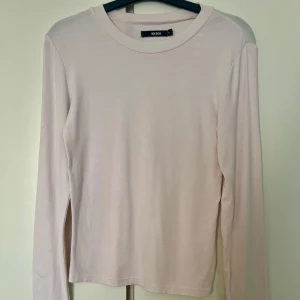 Ljusrosa långärmad tröja Bik Bok - En basic ljusrosa långärmad tröja från Bik Bok i mjuk bomull. Enkel och clean design med rund halsringning och normal passform. Perfekt att styla med jeans eller kjol för en chill look.