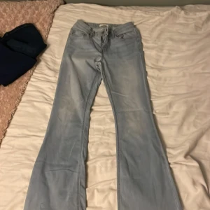 Ljusblå bootcut jeans - Säljer ett par ljusblå jeans med bootcut passform. Jeansen har klassisk femficksdesign och är tillverkade i ett mjukt denimtyg. Perfekta för dig som gillar en retro vibe och vill ha ett par jeans med lite utsvängda ben. Passar för dom med lite bredare lår. Har lite fläckar på benen men syns inte om man inte kollar efter dom. Säljer för  endast för 99kr! 