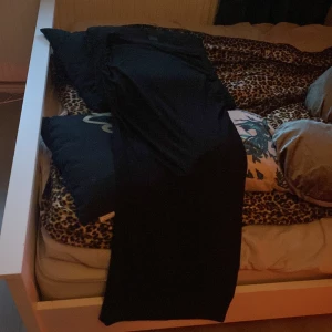 Svart långkjol från Gina Tricot - Säljer en svart långkjol från Gina Tricot i storlek M. Kjolen har en tight passform och snygga rynkdetaljer längs sidorna. Materialet känns mjukt och stretchigt. Orginal priset var 300 kr.