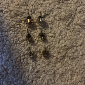 Set med sex par glittriga örhängen - Säljer ett set med sex par små örhängen i olika storlekar. Alla är i guldtonad metall med klara, glittrande stenar som ger en snygg och stilren look. Perfekta att mixa och matcha för flera hål i öronen eller för att variera din stil. 20kr per par OBS!!! KOMMER GÖRAS RENT INNAN SICKAD