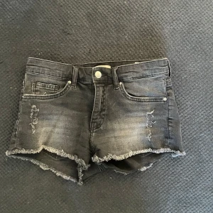 Svarta jeansshorts med fransig kant - Snygga svarta jeansshorts med slitna detaljer och fransig kant nertill. Nästan aldrig använda.