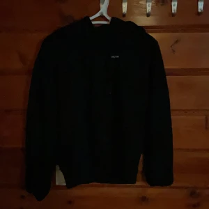 Svart hoodie från H&M Divided XS - Svart hoodie från H&M Divided i storlek XS. Tröjan har huva med snörning och trycket 'original' på bröstet. Klassisk modell med lång ärm och mjukt material, perfekt för en chill och avslappnad stil. Finns en fläck på ena ärmen.