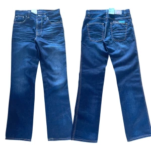 Nudie Jeans Slim Jim straight jeans - Snygga blå jeans från Nudie Jeans, modell Slim Jim med straight tubeleg. Klassisk femficksdesign, kontrastsömmar och mellanblå tvätt. Perfekta för dig som gillar raka ben och stilren look. Materialet är slitstarkt jeans i bomull. Längd: 106 cm! Midja: 38,5 cm! Benöppning: 20cm!