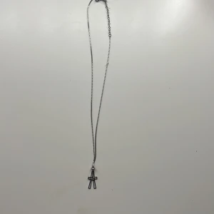 Silverhalsband med dubbla kors - Stilrent halsband i silverfärg med två tunna korshängen. Kedjan är smal och har justerbar längd med karbinlås. Perfekt för dig som gillar minimalistiska smycken med en cool touch.