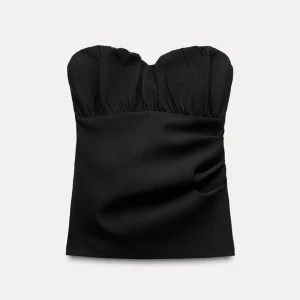 Svart axelbandslös tubtopp - Snygg svart axelbandslös tubtopp med rynkade detaljer upptill. Perfekt för en stilren och elegant look. Passar bra till både jeans och kjol.