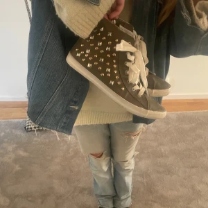 Mörkgröna sneakers med nitar - Säljer ett par olivgröna sneakers med vita snören och silverfärgade/guldförgade nitar på sidorna. Supersnygga vårskor! I storlek 39 och bra skick. Pris kan diskuteras❤️