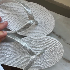 Vita sandaler med glittriga remmar - Snygga sandaler från Antonio med vit, texturerad sula och glittriga silverfärgade remmar. Trendiga och nästintill identiska med de från Ilse Jacobsen. perfekta nu i sommar. 