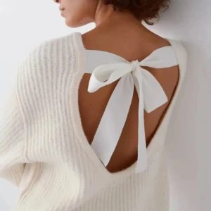 Beige ribbad tröja med knytband - Säljer en stilren beige ribbad tröja med ett dekorativt knytband bak. Tröjan har långa ärmar och en mjuk, bekväm passform. Perfekt för en avslappnad och chic look.