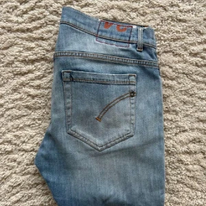 Ljusblå slim jeans från dondup Jeans - Säljer ett par ljusblå slim jeans från dondup Jeans med klassiska fem fickor och slitningar på ena benet. Jeansen har normal passform i midjan och smalare ben. Perfekta för dig som gillar en avslappnad men ändå stilren look. Storlek w33 L33