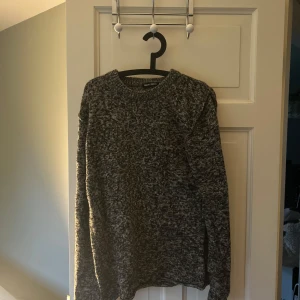 Grå stickad tröja från Filippa K - Säljer en gråmelerad stickad tröja från Filippa K i storlek L. Tröjan har rund halsringning och långa ärmar. Perfekt för kyligare dagar och enkel att matcha med olika outfits.