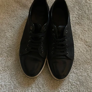 Svarta sneakers från Lanvin med croc-mönster - Säljer ett par riktigt snygga svarta och mörkblåa sneakers från Lanvin med croc-mönstrad ovandel och vita sulor. Dem är i storlek 46-47 och är väldigt stilrena och sköna. Hör av dig ifall du undrar något😁