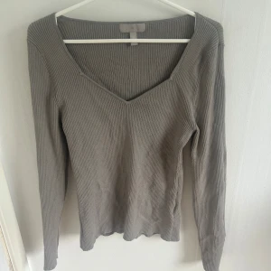 Grå ribbad långärmad tröja från H&M - Säljer en grå ribbad långärmad tröja från H&M med v-ringad halsringning. Tröjan är i mjukt material och har en figurnära passform som passar perfekt till vardags. Enkel och stilren design som är lätt att matcha. Nopprig vilket syns på sista bilden 