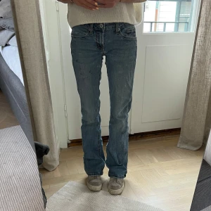 Blå bootcut jeans från Stetson - Säljer ett par klassiska blå jeans med bootcut passform och låg midja. Sitter snyggt och är i fint skick. Jag är 169 cm lång, och på bilderna är mitt innerbensmått ca 82,5 cm och midjemått (platt mätt på mig) ca 31 cm. Har små bläck fläckar som inte går bort, men inget man tänker på. 