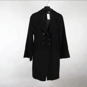 Svart kappa från Hugo Boss - Lyxig kappa från Hugo Boss i 60 % ull och 40 % alpacka. Figursydd silhuett, dubbelknäppt modell i svart – tidlös, elegant och varm. Nypris ca 5000–6000 kr. I mycket fint skick och sparsamt använd. Perfekt investering för dig som söker klass och kvalitet. Ingen prutning, men bundlerabatt vid flera köp. Rensar garderoben – kika gärna på mina andra annonser också! 