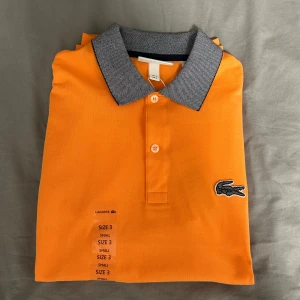 Lacoste piké  - Denna vackra piken har ej använts en ända gång och har fortfarande sin lapp kvar.