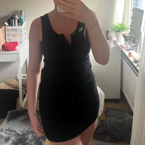 Svart kortklänning från XOXO friends - Säljer en svart, tight kortklänning från XOXO friends. Klänningen är ärmlös med v-ringning och har en figurnära passform som framhäver siluetten. Perfekt för dig som gillar en enkel men stilren look. Hör av er vid fler frågor eller bilder!💛
