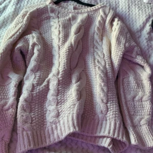 Beige stickad tröja med flätmönster från H&M - Säljer en chunky beige stickad tröja från H&M med snygga flätmönster framtill och på ärmarna. Tröjan har lång ärm och en lite lösare passform. 