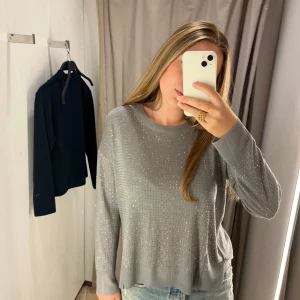 Grå och silvrig tröja från Zara - Säljer en grå silvrig tröja/top eftersom jag föredrar guld och varmare toner. Perfekt för dig som vill ha något enkelt men ändå med lite extra bling.💗