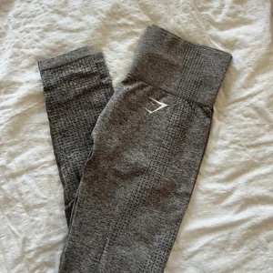 Grå seamless tights från Gymshark - Säljer ett par grå seamless tights från Gymshark med hög midja och diskret mönster. Perfekta för träning och har en tight passform som sitter bekvämt. Gymshark-logga på höften.