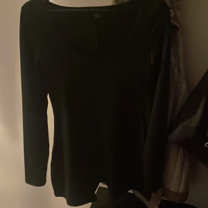Svart långärmad lår längd bodysuit  - En enkel och stilren svart långärmad bodysuit med rund halsringning. Perfekt basplagg som funkar till många olika outfits. Mjuk och skön att ha på sig.