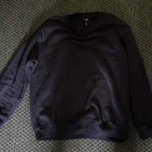 Mörkblå sweatshirt från H&M - En enkel och stilren mörkblå sweatshirt från H&M med relaxed fit. Tröjan har rund halsringning och långa ärmar, perfekt för en avslappnad look. Passar bra till jeans eller joggers.