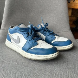 Jordan 1 sneakers -  Färg: true blue cement grey. Skick: Bra skick, har lite creases och små defekter som inte påverkar helheten.  Nypris: 1660 kr på restock 2023 Storlek: 39 och sann till storlek. Passar också mig som har 38/38,5