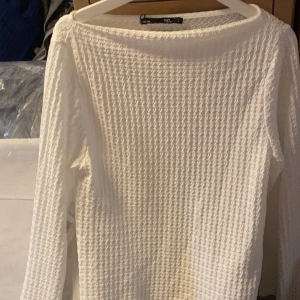 Vit långärmad ribbad tröja från 157 - Säljer en vit långärmad tröja från 157 med ribbad struktur. Tröjan har en rund halsringning och är perfekt för lager-på-lager. Enkel och stilren design som passar till mycket.