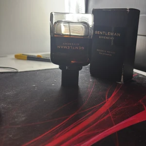 Gentleman Réserve Privée Eau de Parfum från Givenchy - En elegant parfymflaska från Givenchy, Gentleman Réserve Privée Eau de Parfum. Flaskan är mörkbrun med svart kork och har guldtext. Kommer med originalkartong i svart med guldtext. Doften är exklusiv och maskulin. Pris kan diskuteras 
