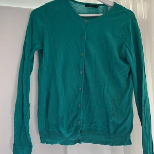 Turkos kofta från Åhléns - Säljer en turkos kofta från Åhléns i storlek S. Koftan har långa ärmar, rund halsringning och knäppning framtill med matchande knappar. Materialet är tunt och stickat, perfekt för lager-på-lager-stil. Jag säljer denna för 110 kr + frakt!