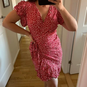 Sommarklänning - Knälång sommarklänning i rött och vitt blommigt mönster med knytning i midjan 💌 Materialet är skönt och luftigt 🌞
