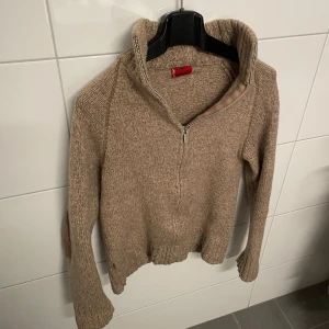 Beige stickad tröja med dragkedja från Levi's - Säljer en beige stickad tröja från Levi's Red Tab i storlek small. Tröjan har förstärkta mockadetaljer på armbågarna. Tillverkad i 100% ull från Shetland. Hör av dig vid funderingar.