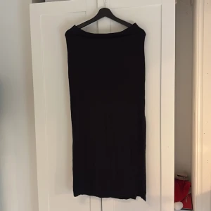 Svart långkjol från Gina Tricot - Säljer en svart långkjol från Gina Tricot. Kjolen har en enkel och stilren design utan synliga detaljer eller mönster, perfekt för dig som gillar minimalistiskt mode. Perfekt nu inför sommaren. Hör av dig vid intresse!💕
